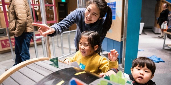 Parents and two little kids at a museum exhibit.