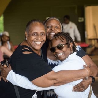 Homeowners embrace at community gathering.