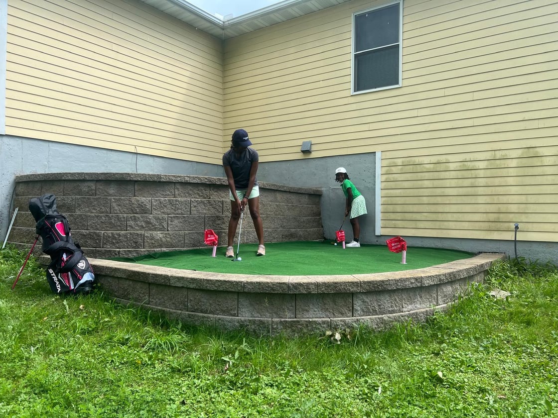Joyce and her daughter on their putting green.
