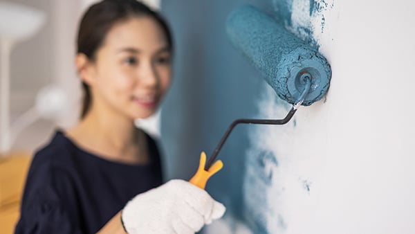 Woman using a paint roller.